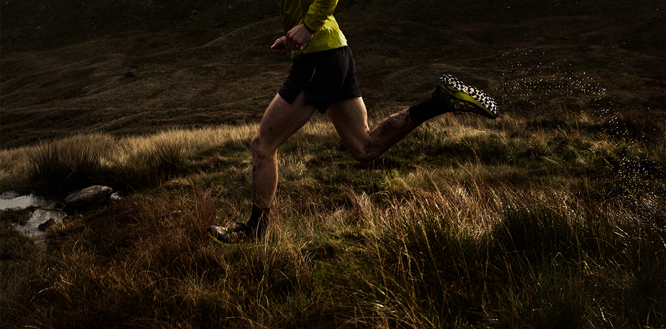 Athletes running through a muddy field with mud on their legs