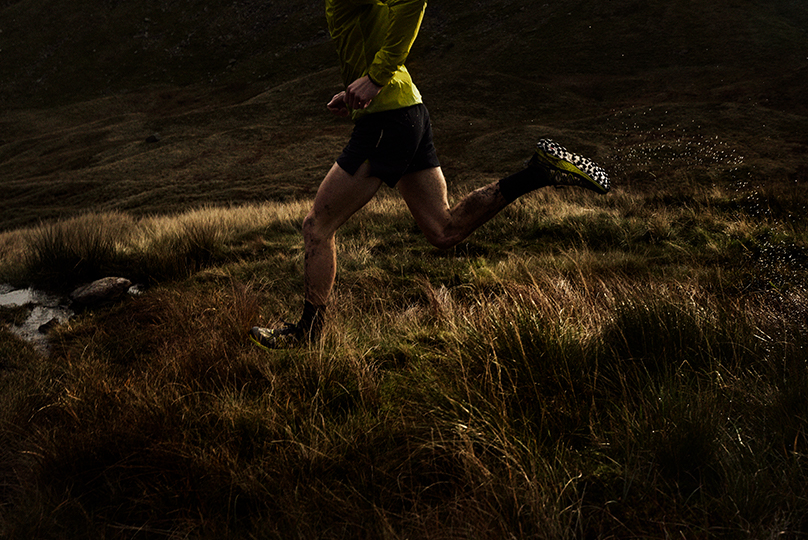 Athletes running through a muddy field with mud on their legs