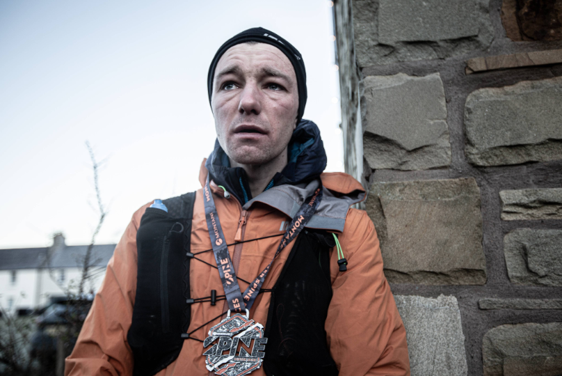 The exhaustion and emotion hits Jack Scott at the finish of his record-breaking Winter Spine Race run in 2024. Photo by Adam Jacobs for Spine Race.
