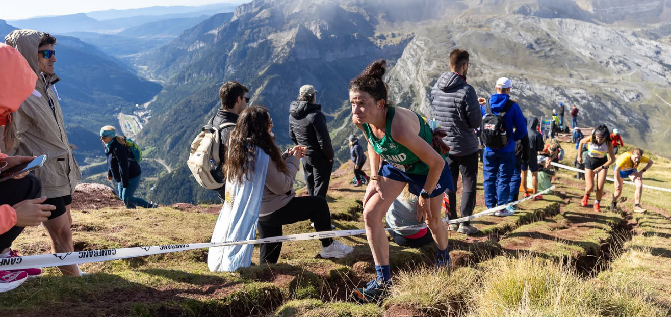 INOV8 Athlete Sarah McCormack climbing up a long, steep sunny mountain side