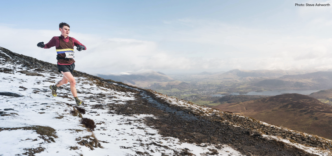 Tom Spencer running down a snowy hillside during the Coledale Horseshoe