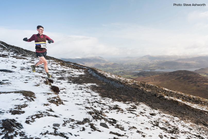 Tom Spencer running down a snowy hillside during the Coledale Horseshoe