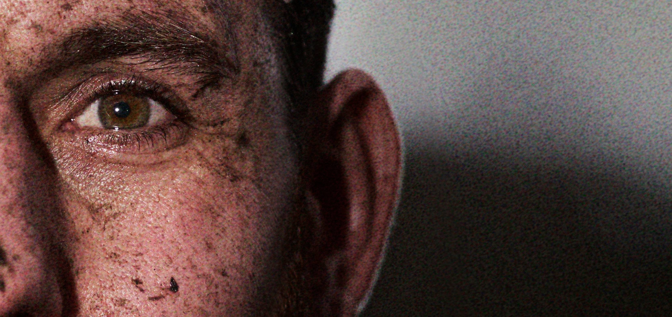 Close up portrait of INOV8 Athlete Andy Berry covered in mud