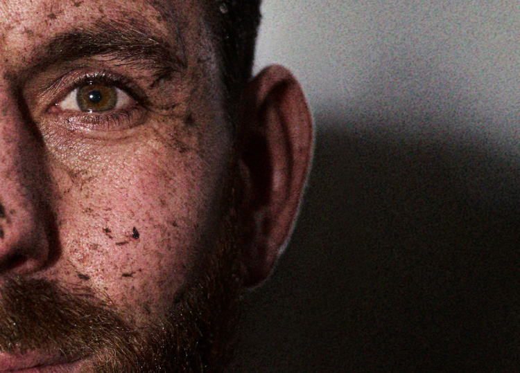 Close up portrait of INOV8 Athlete Andy Berry covered in mud