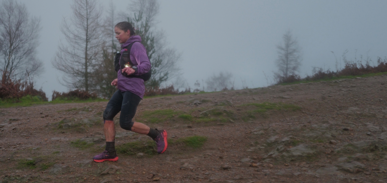 INOV8 Athlete Sarah Perry racing down a rainy trail at 'The Hill' event