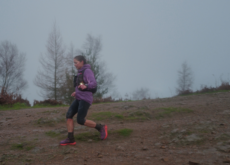 INOV8 Athlete Sarah Perry racing down a rainy trail at 'The Hill' event