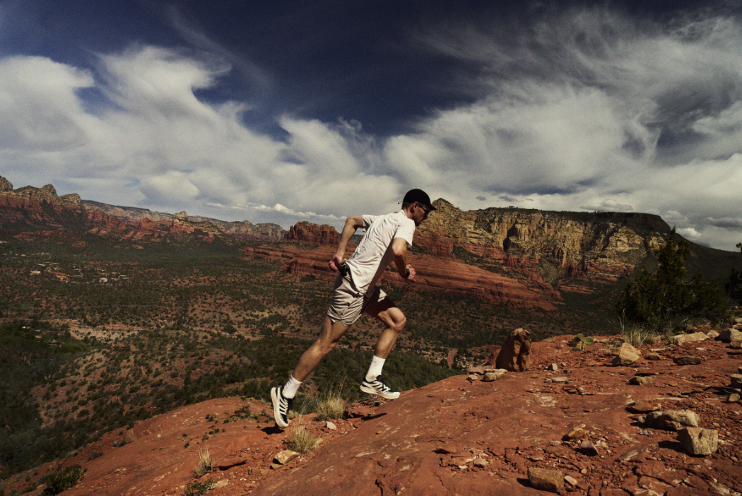 Jack Scott running along a desert ridge with a red, sandy background