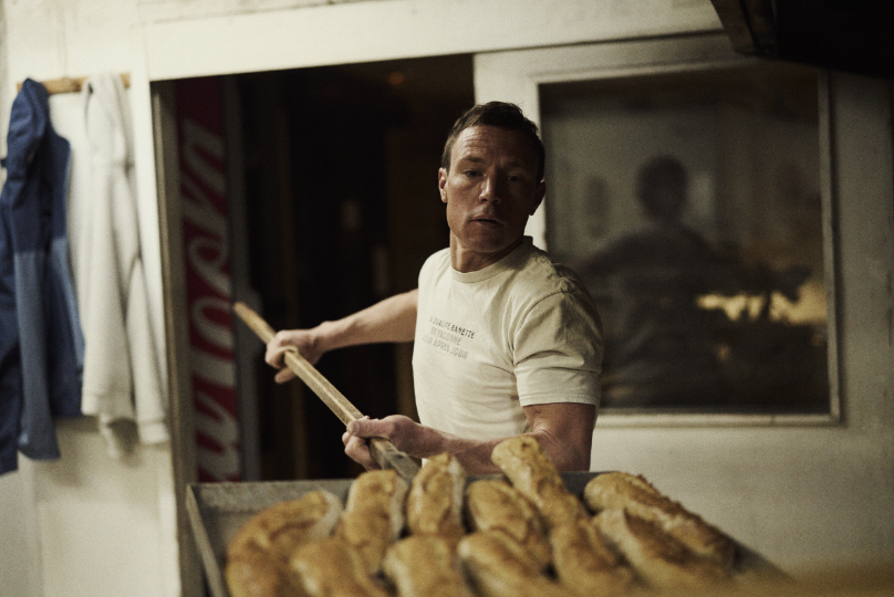 INOV8 Athlete Yannick Noel carrying trays of bread inside a commercial bakery.