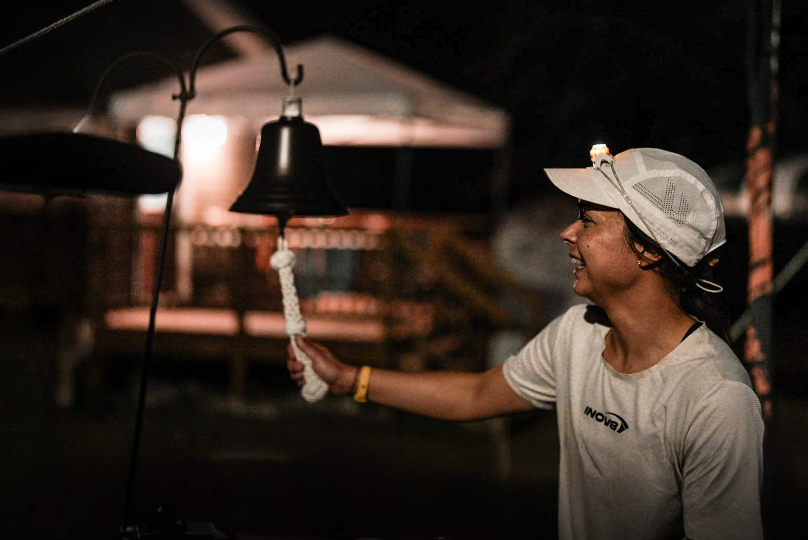 INOV8 Athlete Sarah Perry celebrating breaking a record by ringing a bell