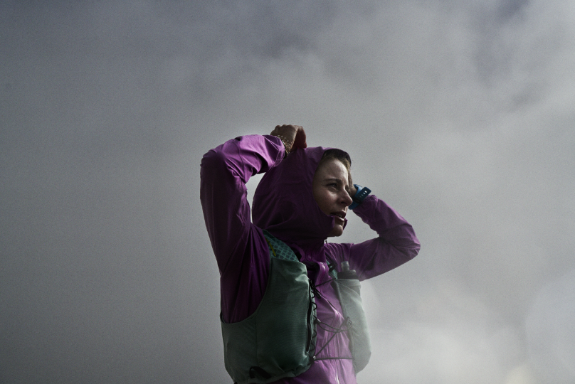 Runner wearing a waterproof jacket with the hood up