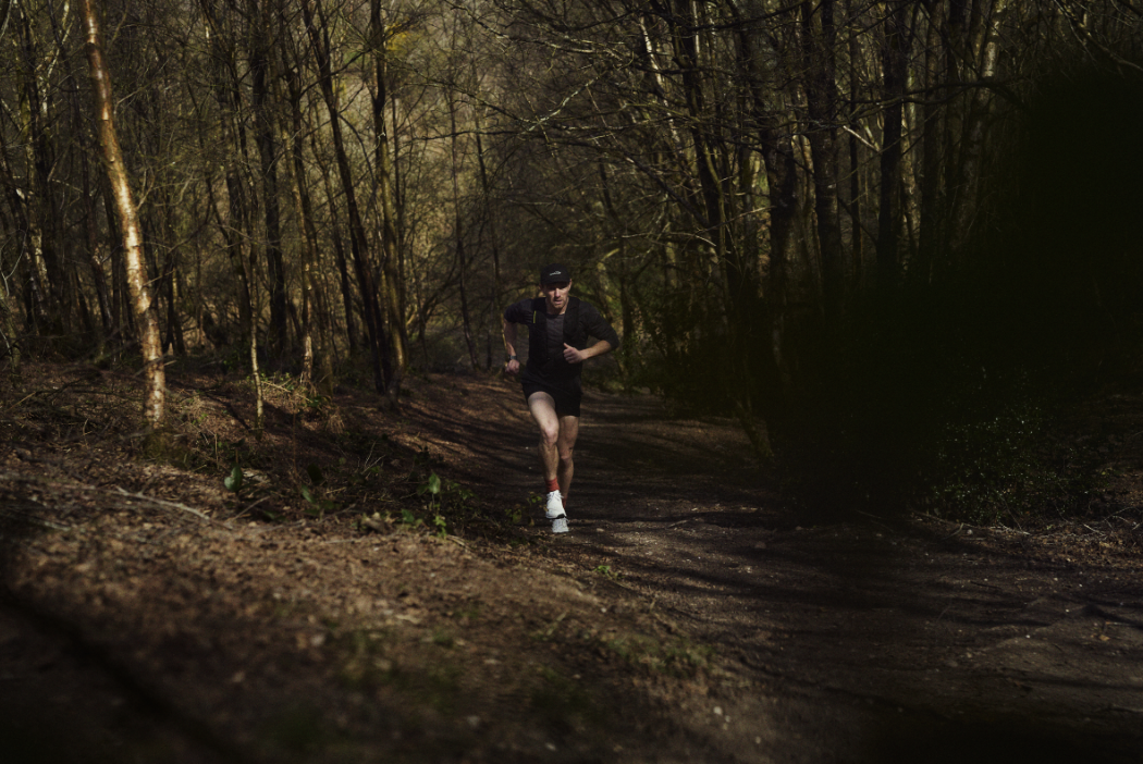 Jack Scott running up a path in a dark wood
