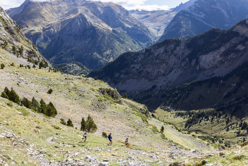 GB Athletes running down a green and rocky mountain slope